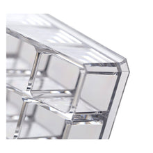 Clear acrylic display stand for cosmetics with 24 compartments, focusing on its practical use